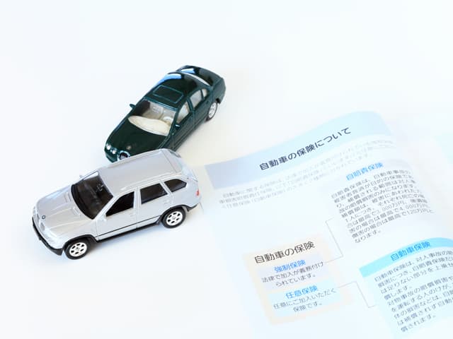 自動車保険のパンフレットとミニカー